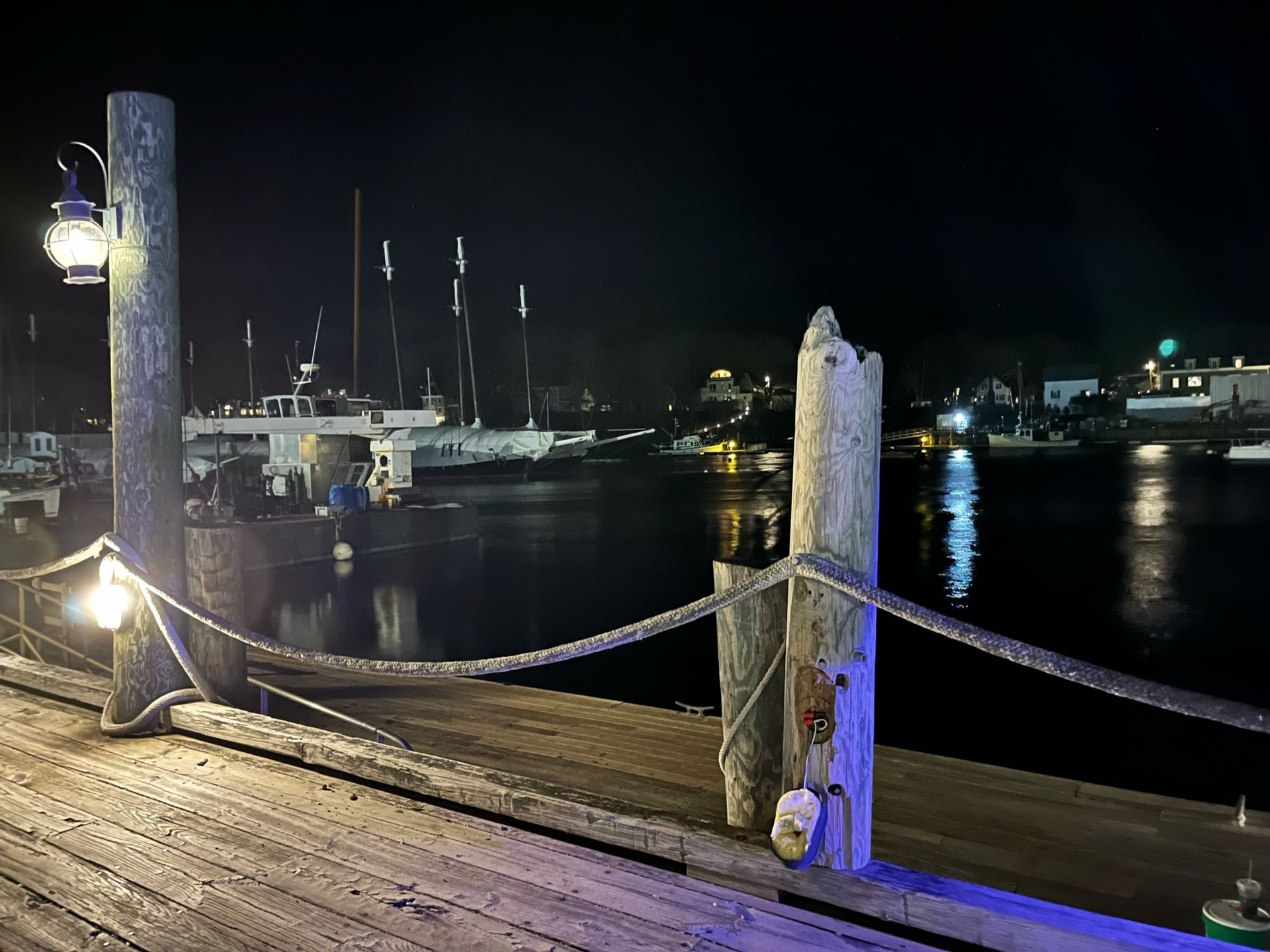 A dock at night with boats in the background