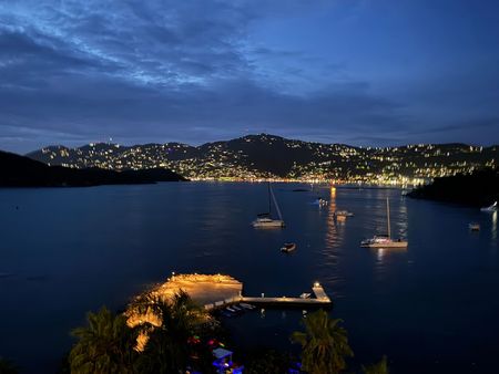 A large body of water with boats in it at night.