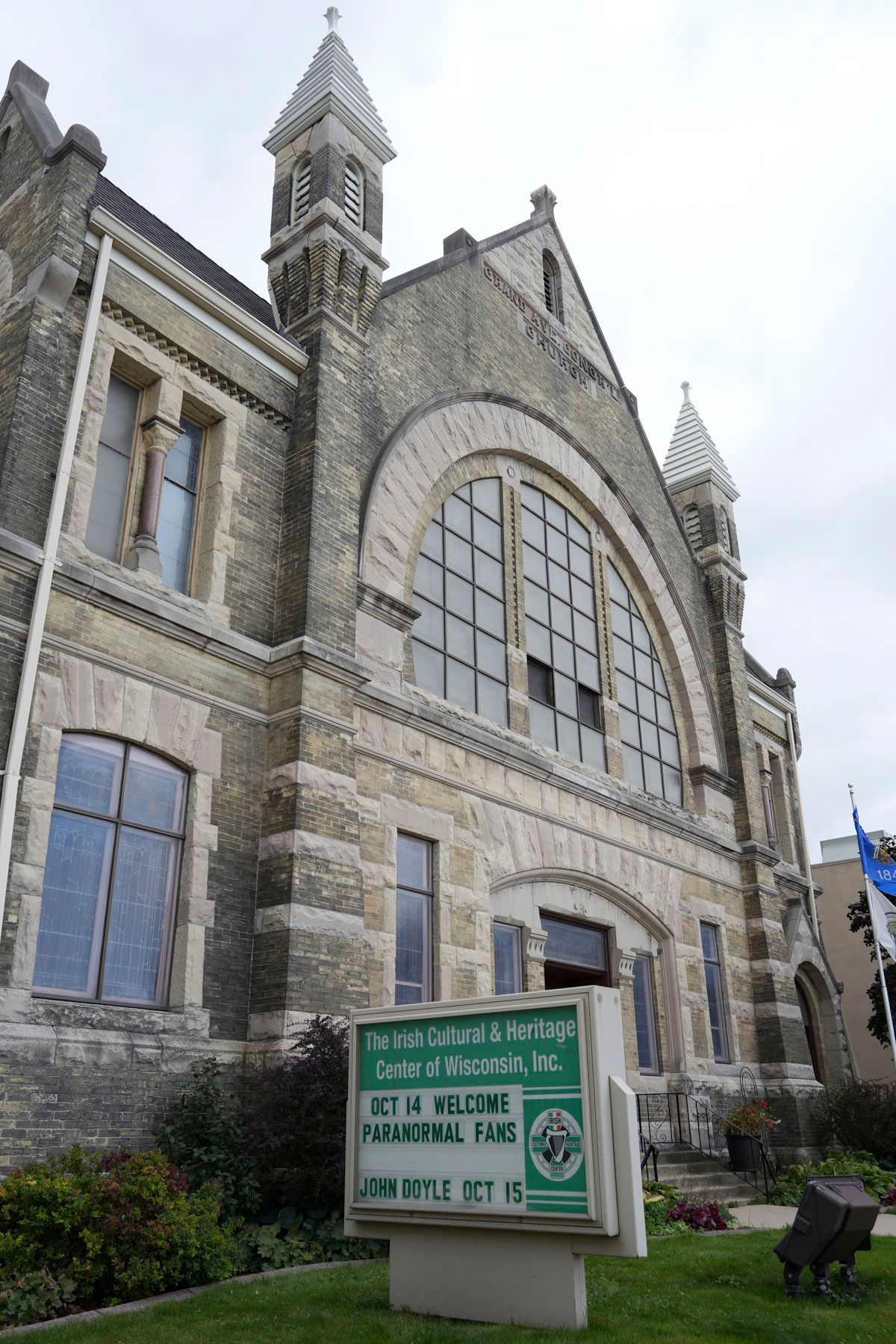 A large stone building with a green sign in front of it