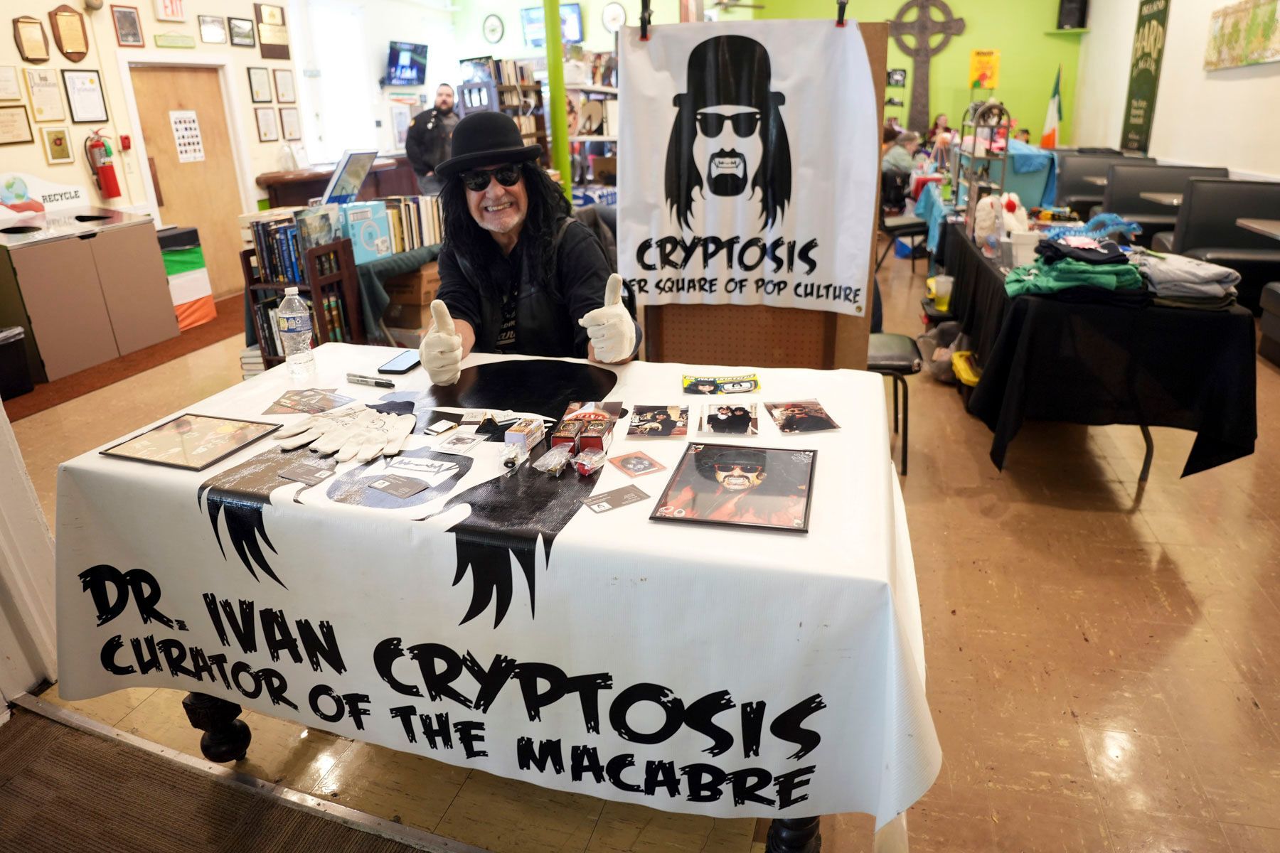 A man sits at a table with a sign that says dr. ivan cryptosis