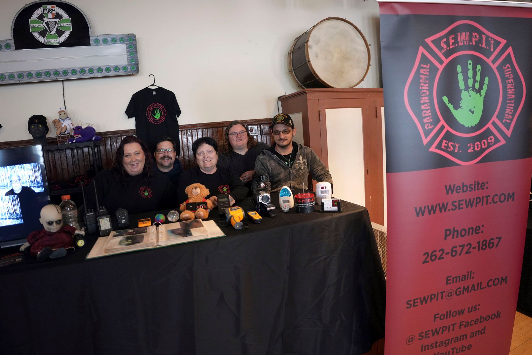 A group of people standing around a table with a sign that says temptation