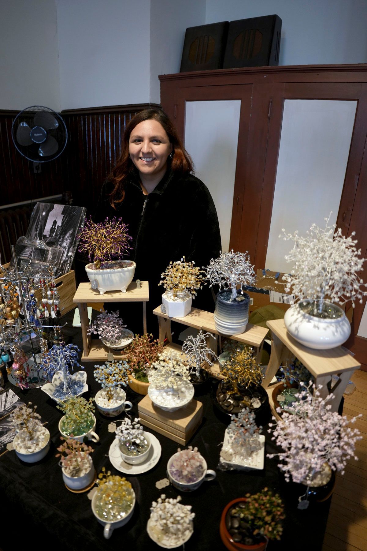 A woman stands in front of a table full of flowers