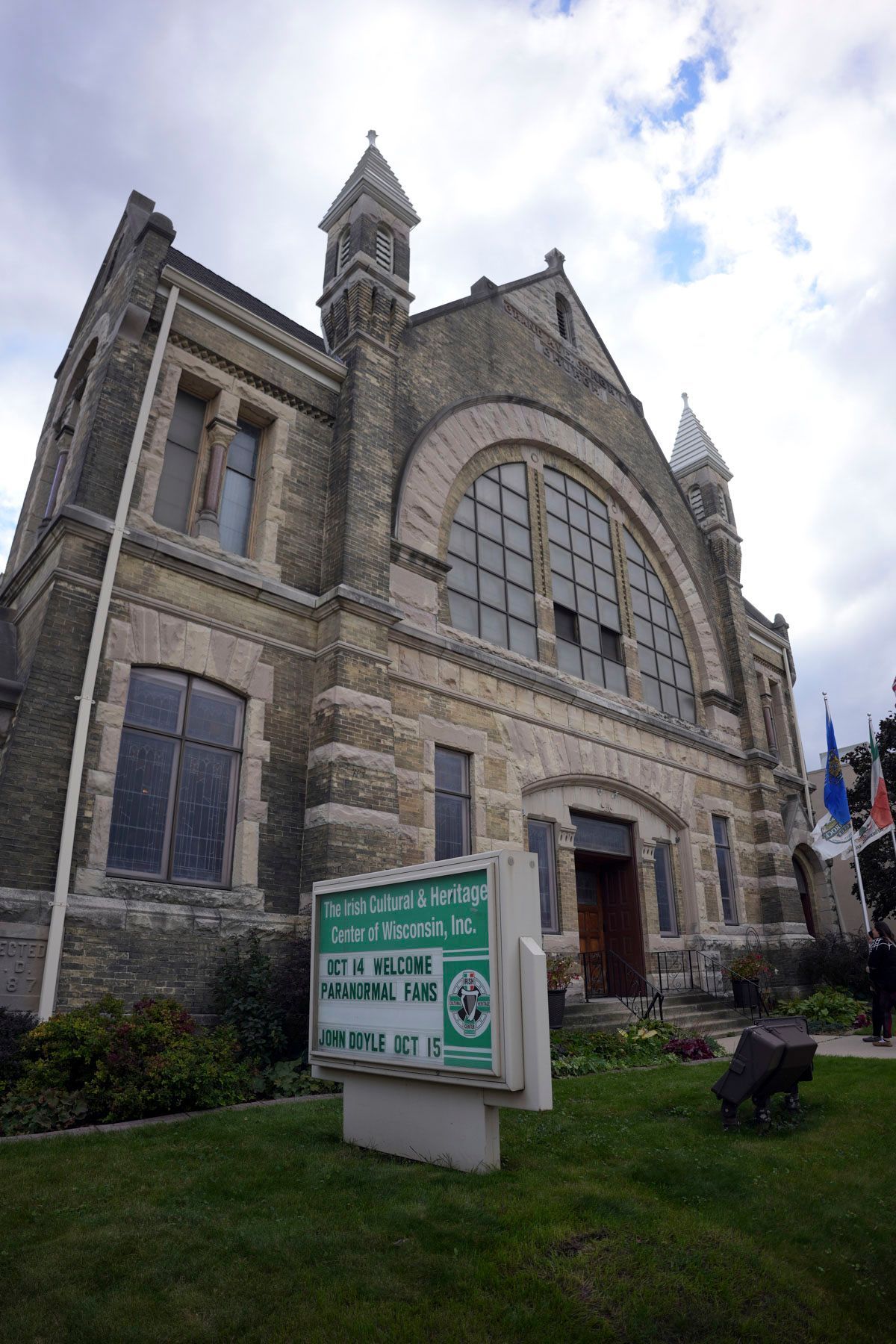 A large stone building with a sign in front of it that says welcome