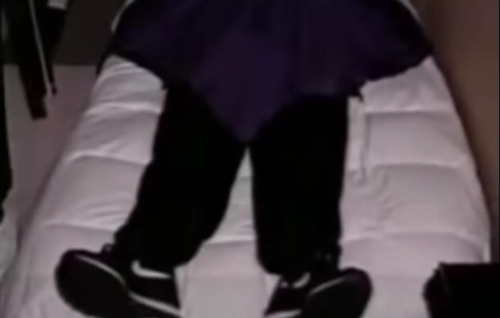 A screenshot of a  deceased Heaven's Gate cult member with his Nike shoes on