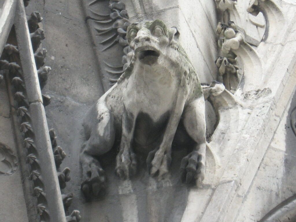 A statue of a gargoyle on the side of a building