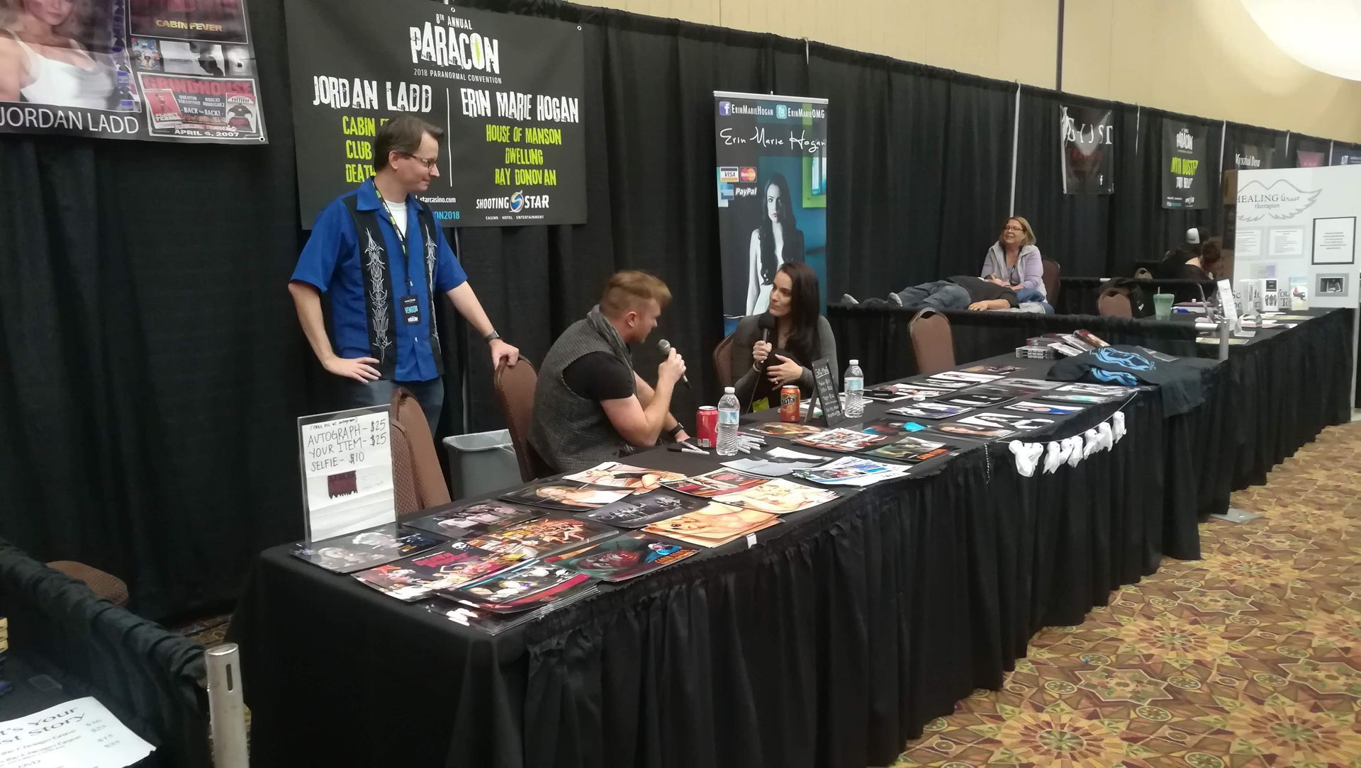 A group of people standing around a table at a convention