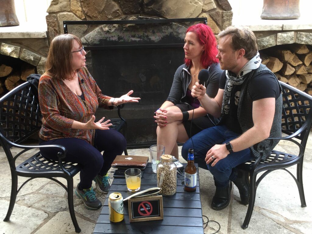 A group of people are sitting around a table talking to each other.