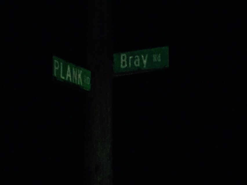 A street sign for bray rd is lit up in the dark.