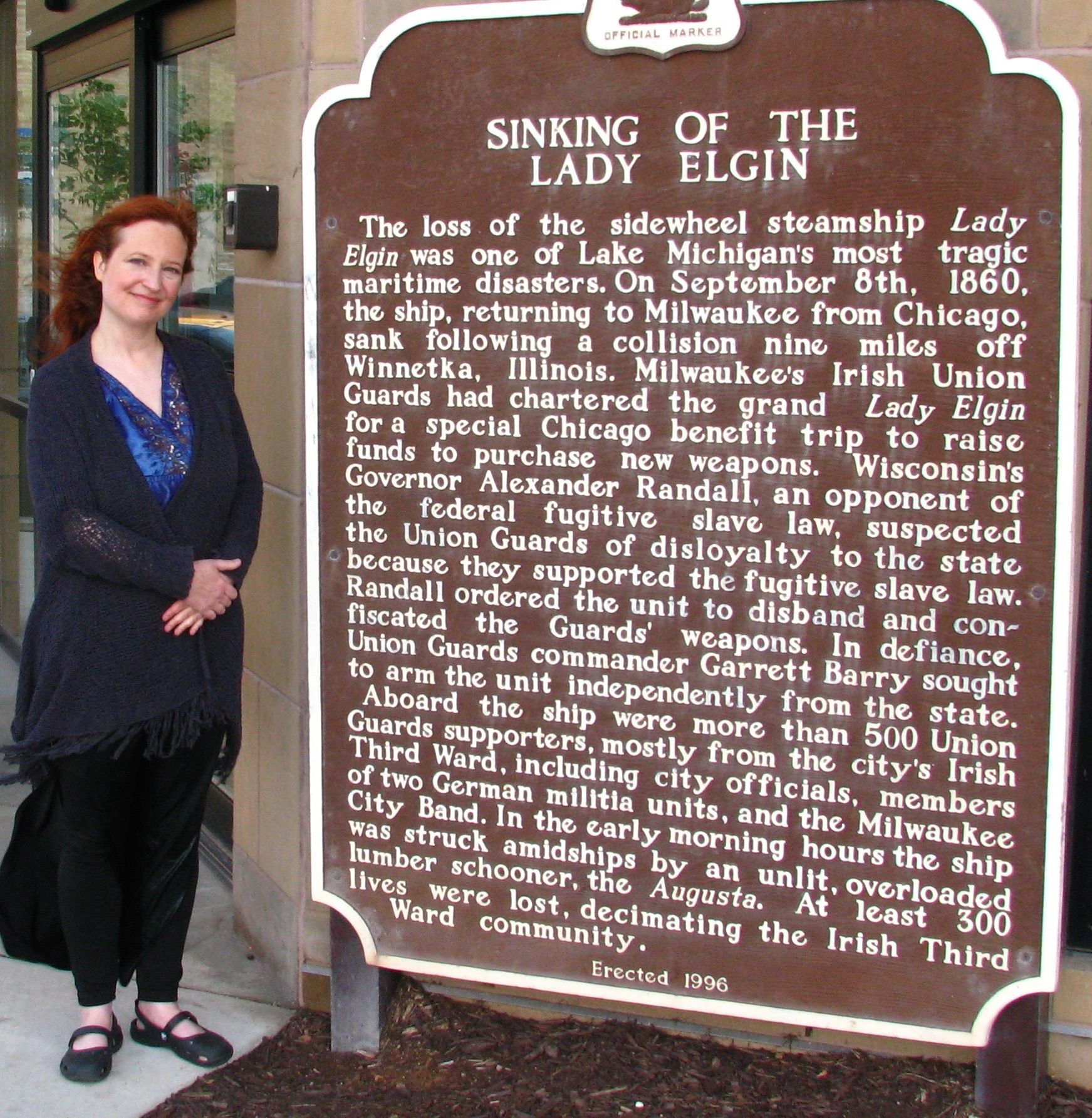 Allison Jornlin standing next to the Lady Elgin memorial marker in Milwaukee's Third Ward