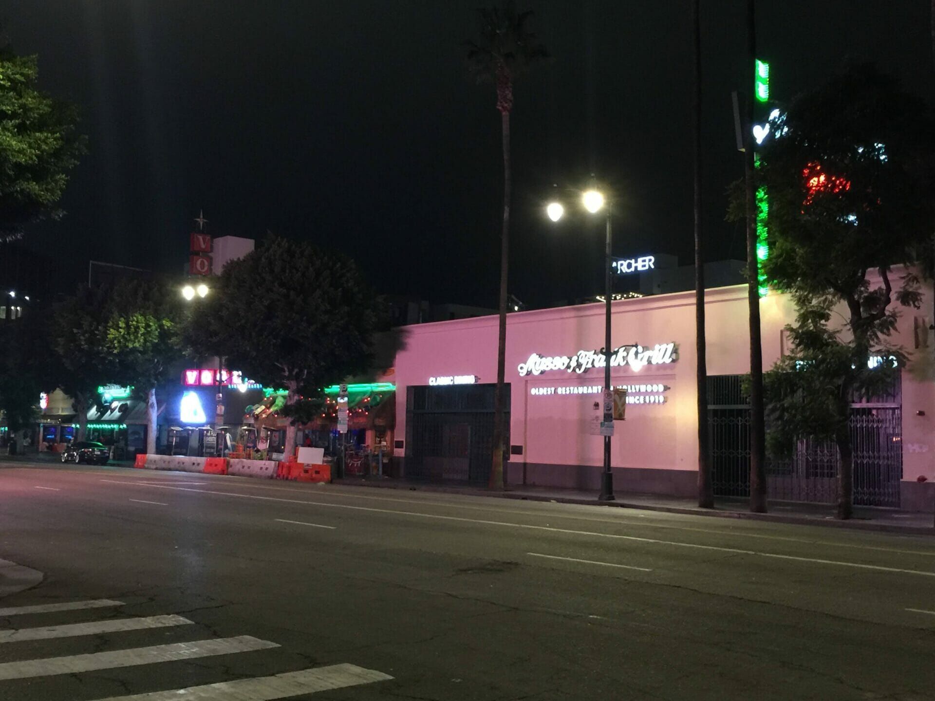 A restaurant called american grill is lit up at night