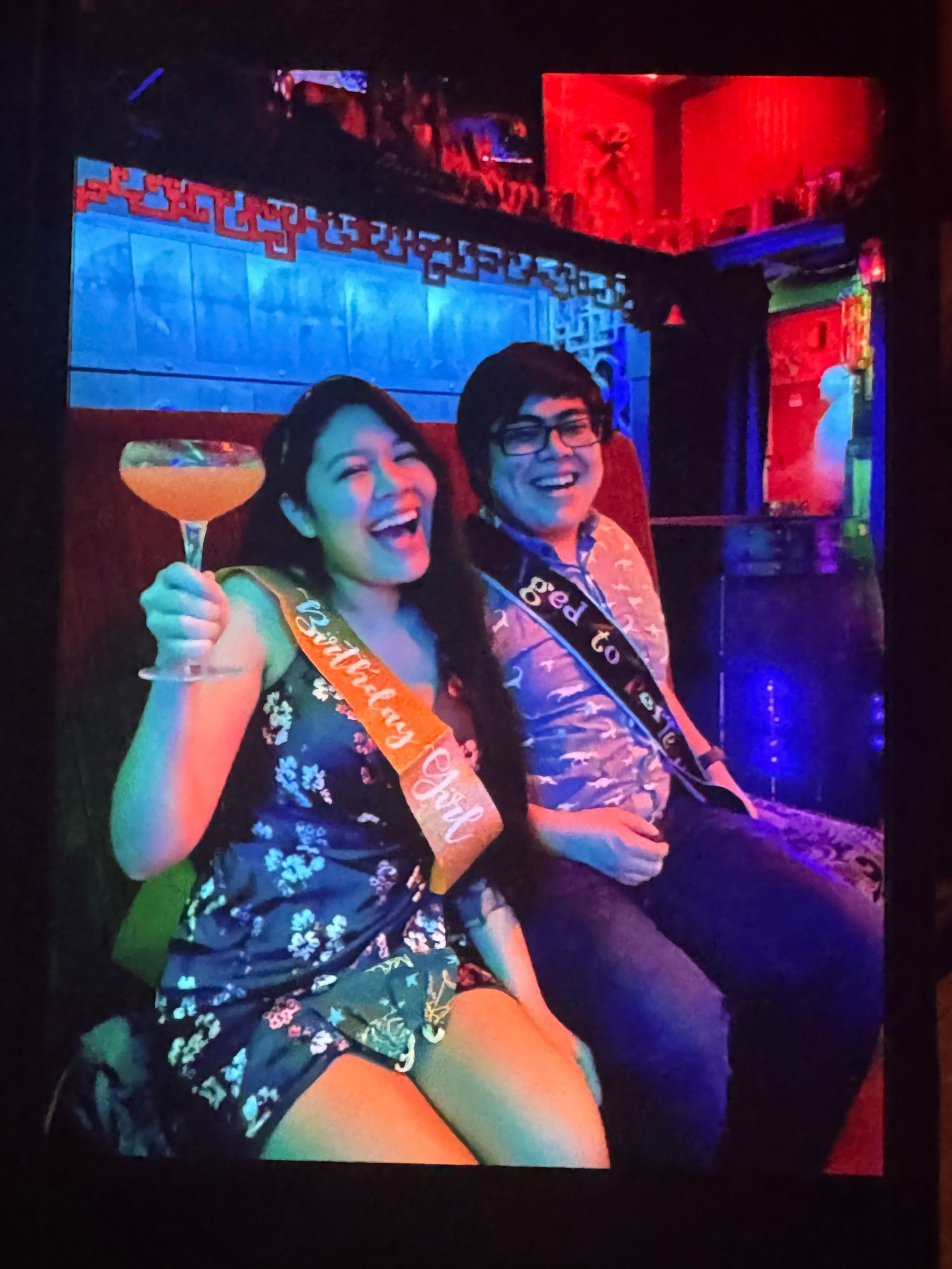 Image of a couple at the Golden Tiki with a strange ghost in blue behind them