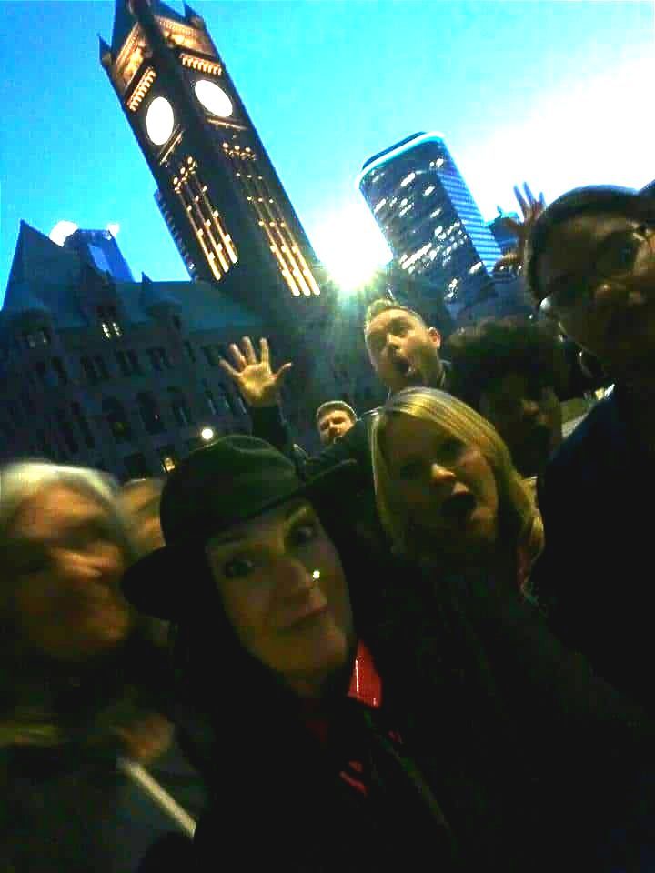 A group of people are posing for a picture in front of a clock tower