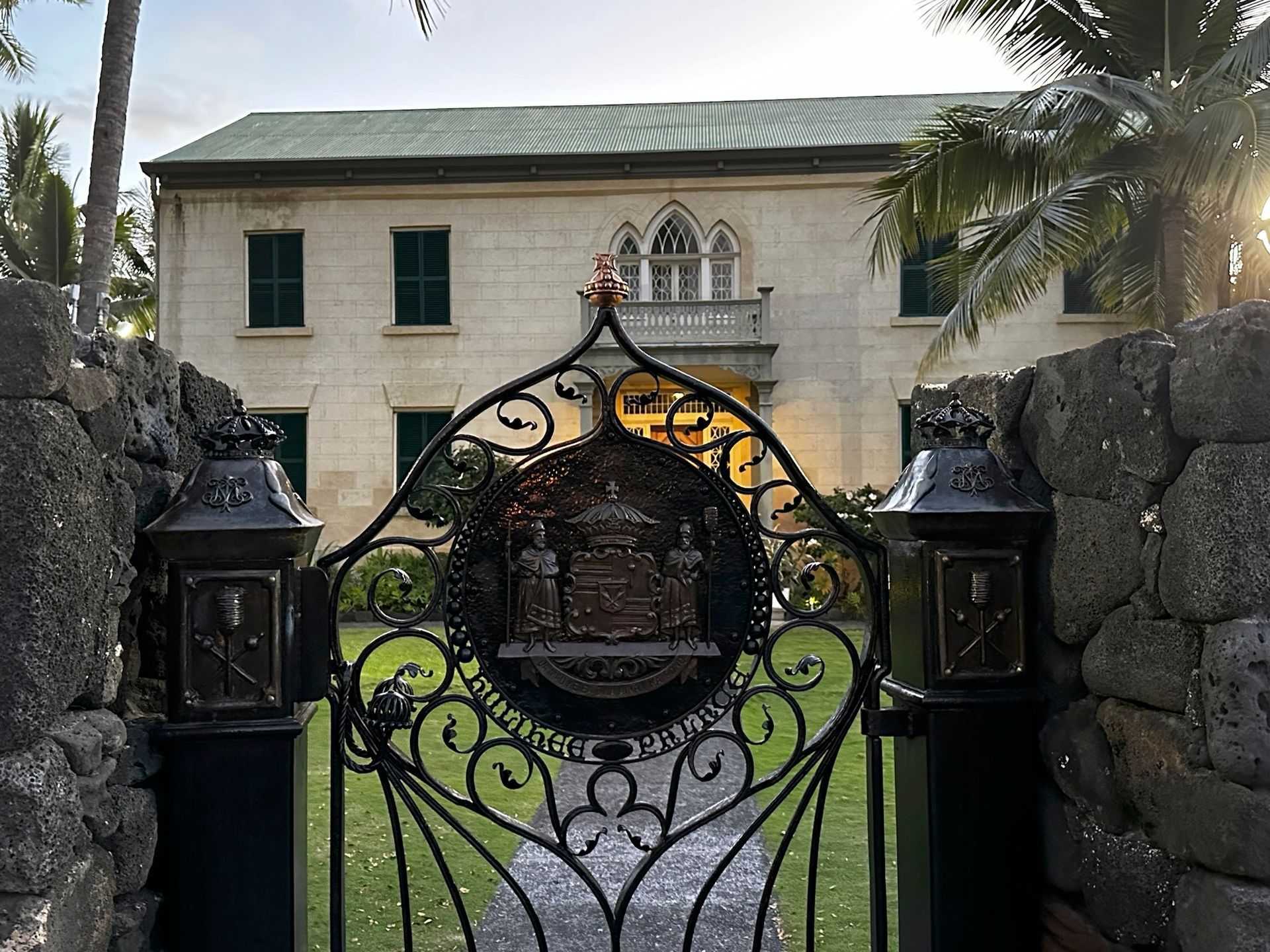 A wrought iron gate leading to a large house