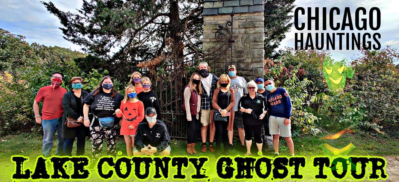 A group of people are posing for a picture in front of a building that says lake county ghost tour