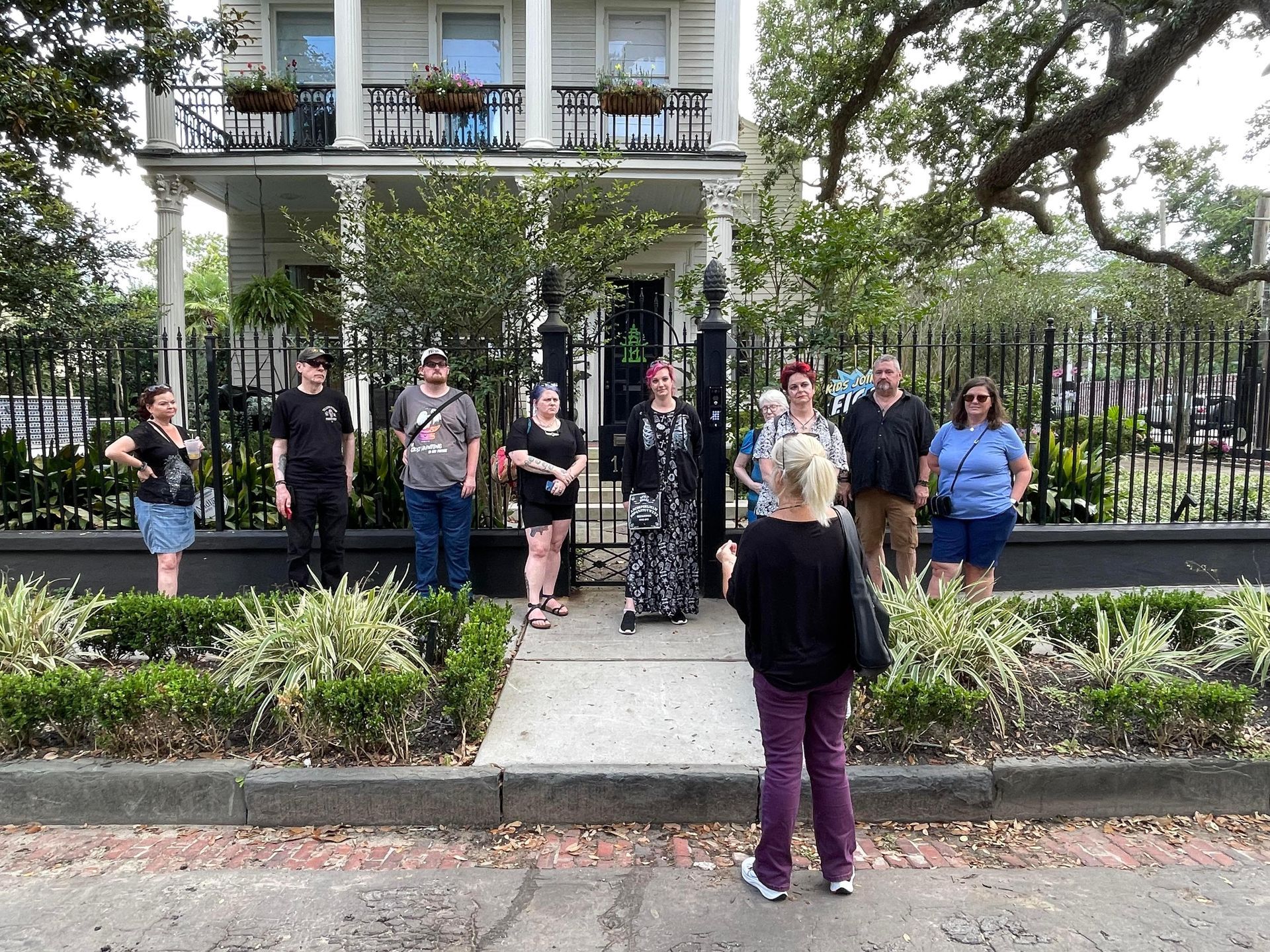 A group of people standing in front of a house