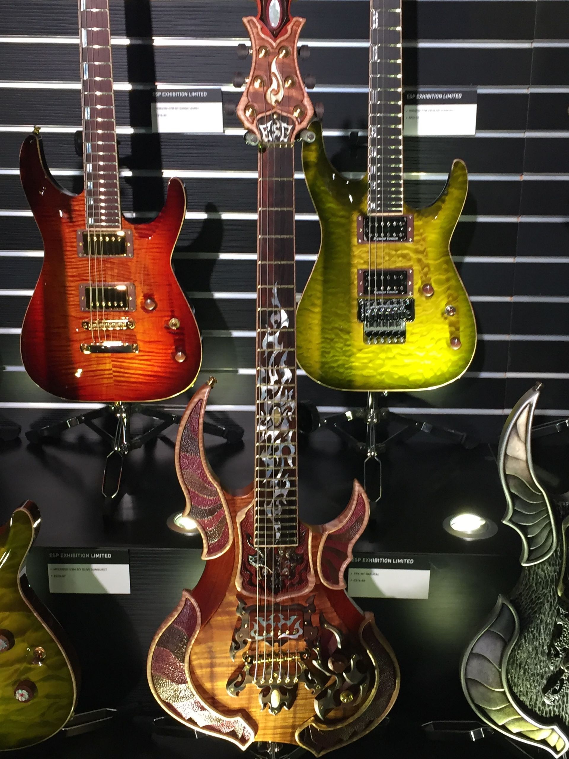 A row of guitars are hanging on a wall