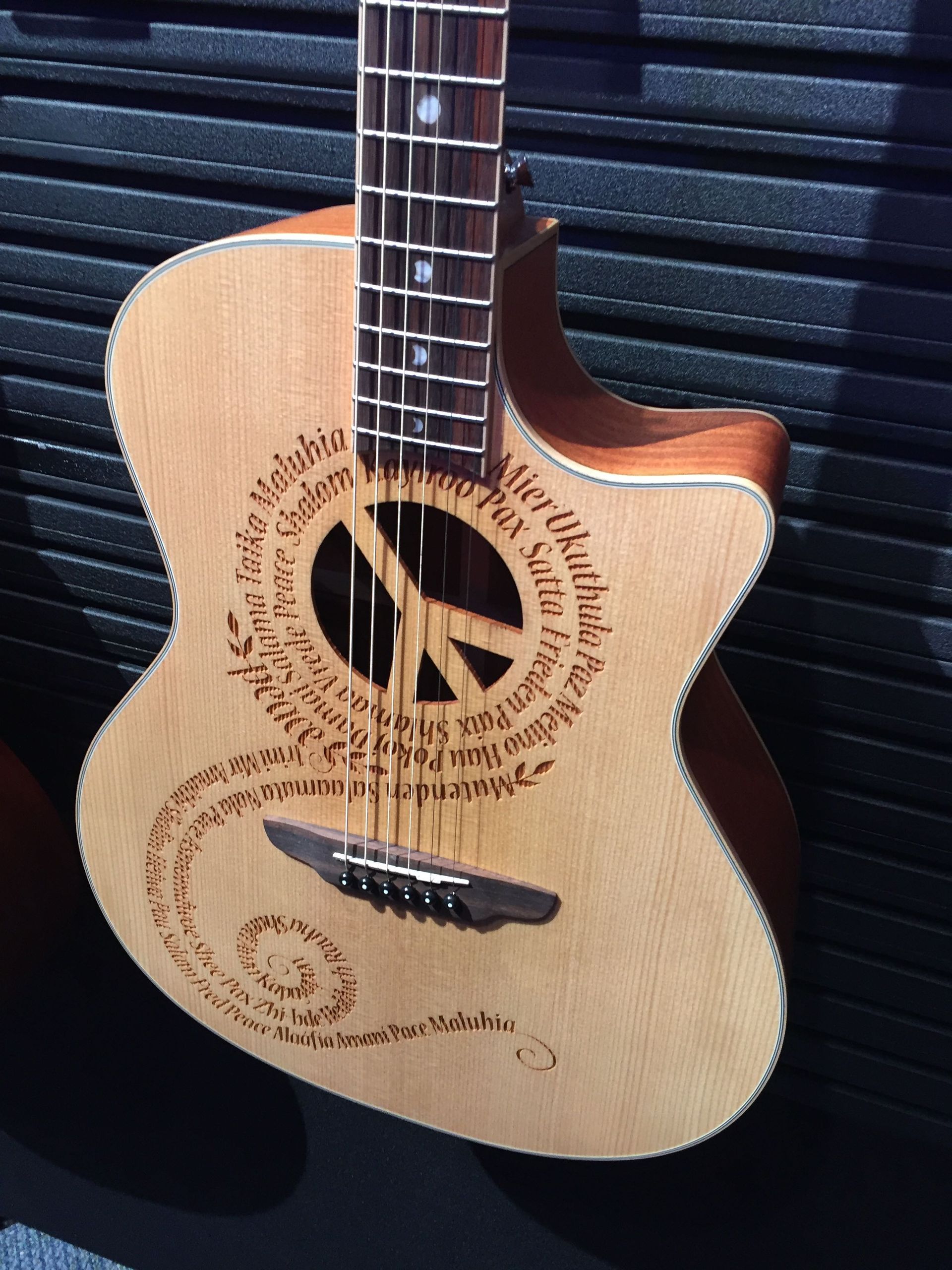 An acoustic guitar with a peace sign on it