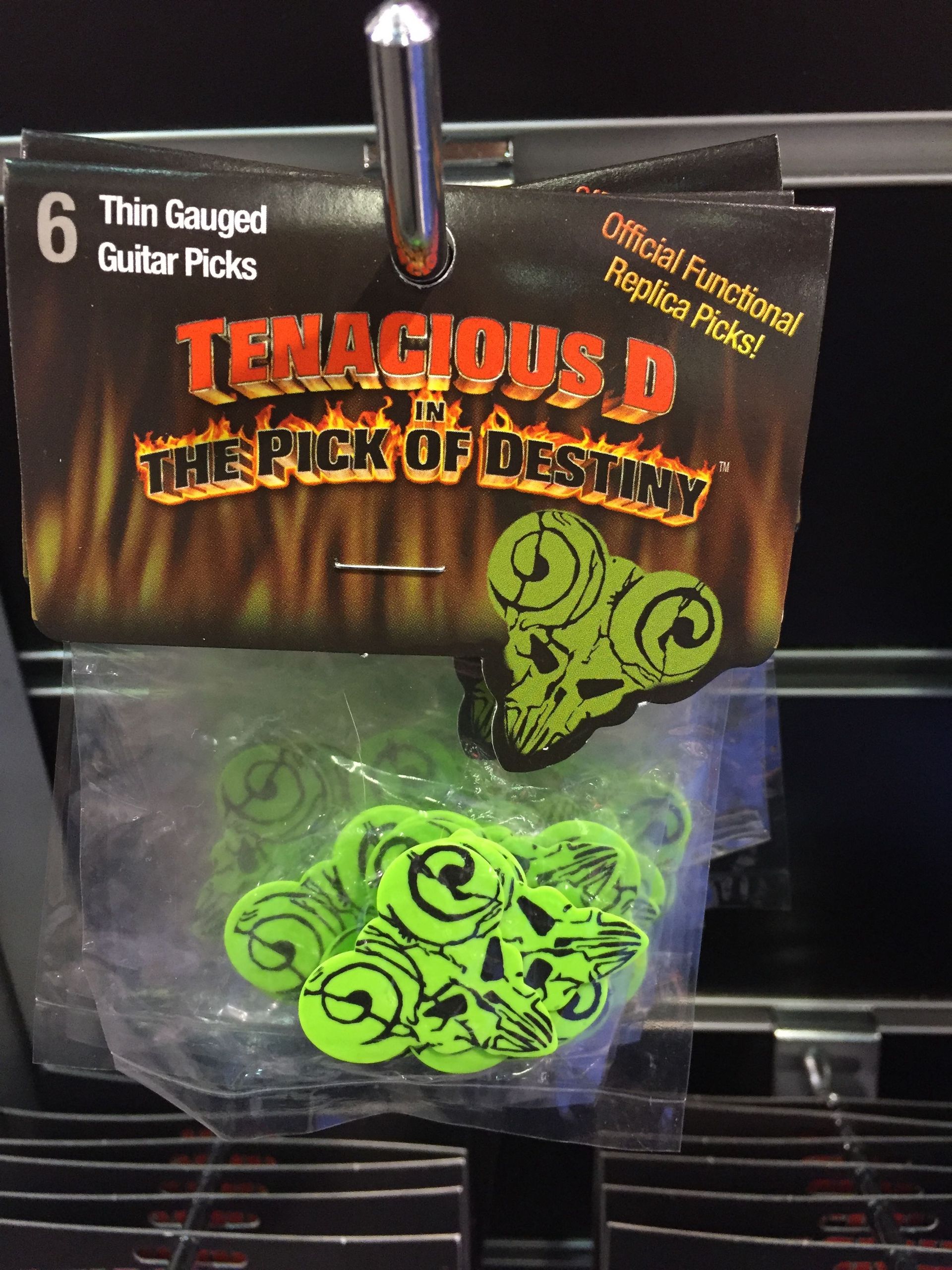 A package of tenacious d guitar picks hanging on a shelf