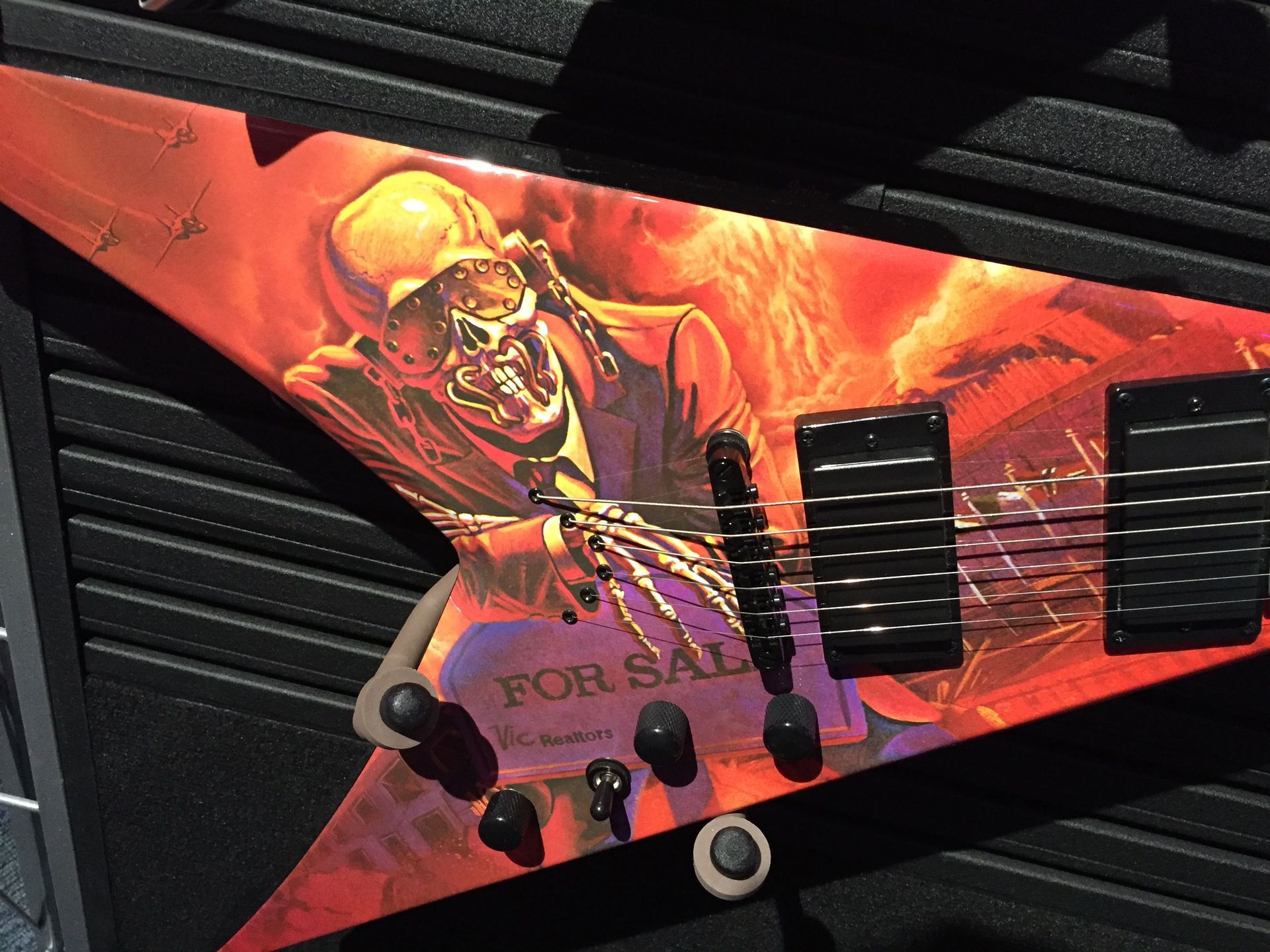 A guitar with a for sale sign on it