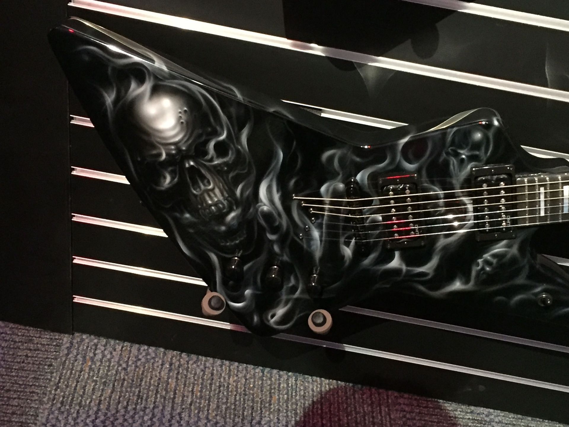 A guitar with a skull and flames painted on it