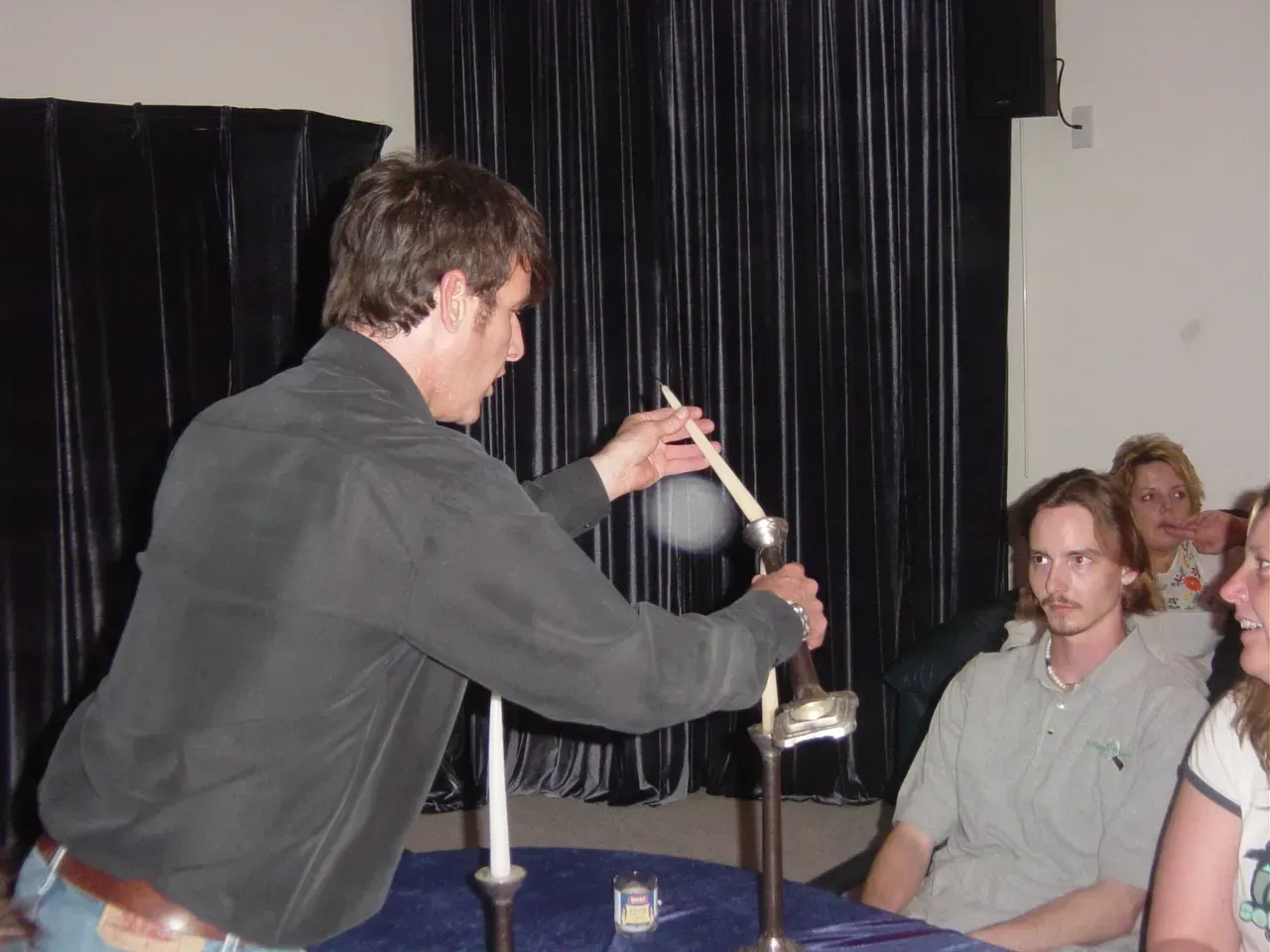 A man is holding a candle in front of a group of people