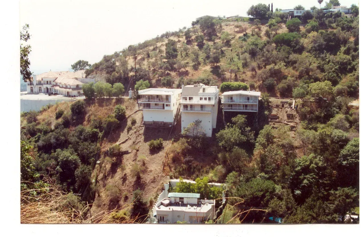 A house sits on top of a hill surrounded by trees