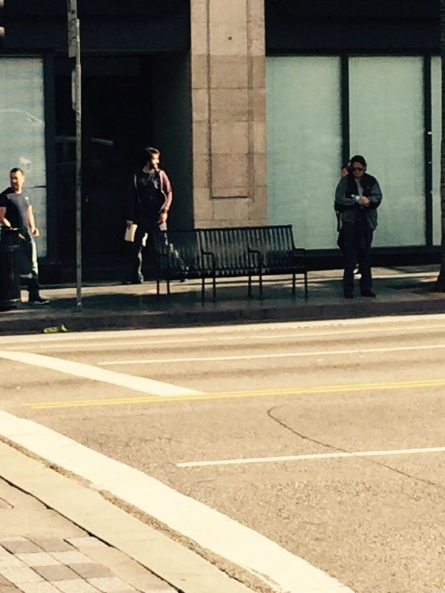 A group of people are waiting at a bus stop