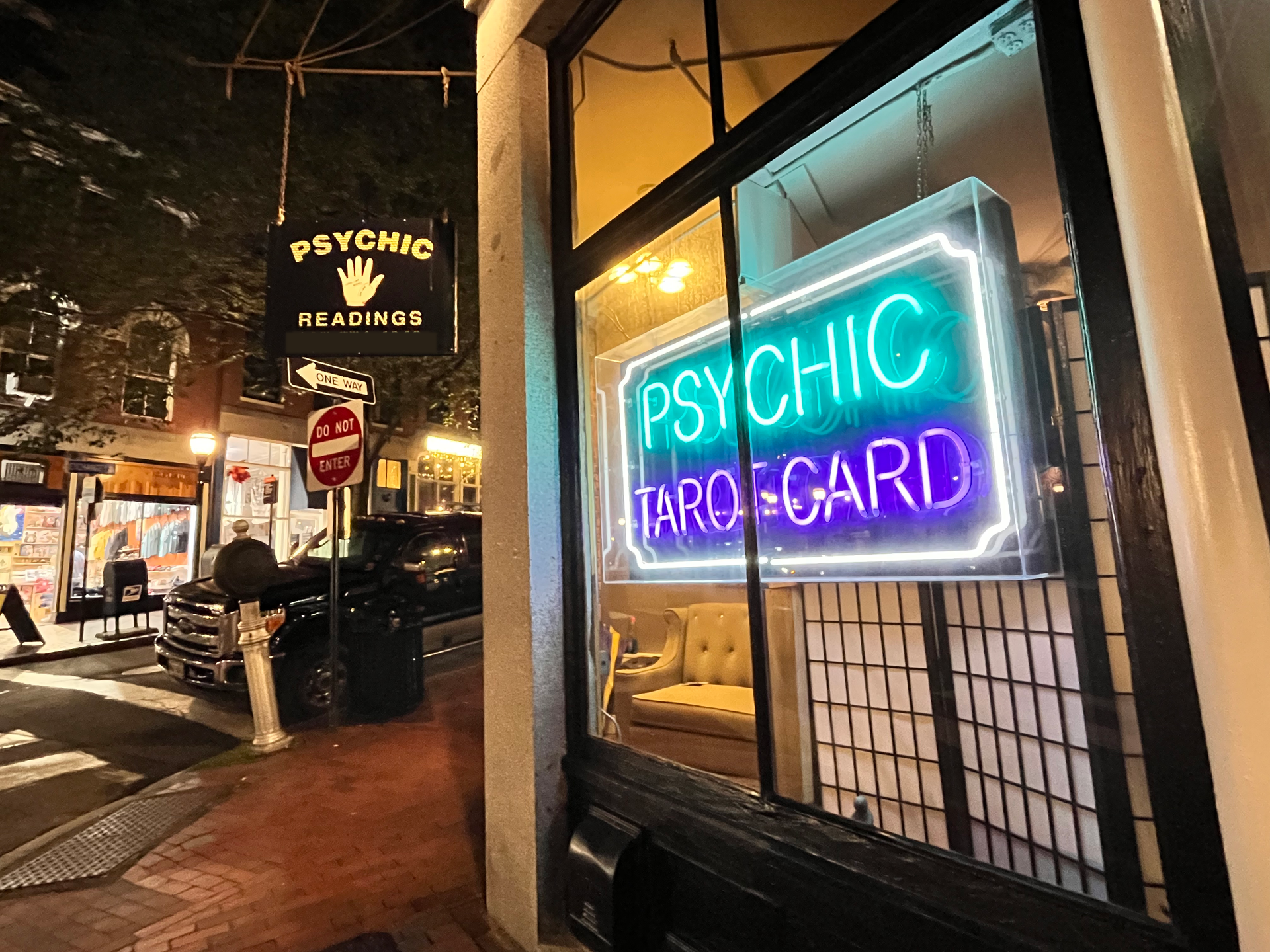 A store front with a neon sign that says psychic tarot card