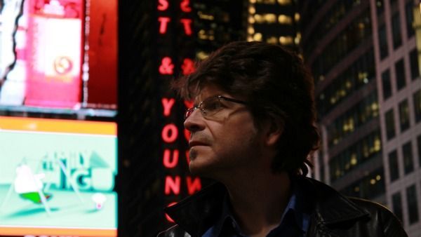 A man stands in front of a sign that says ' you ' on it