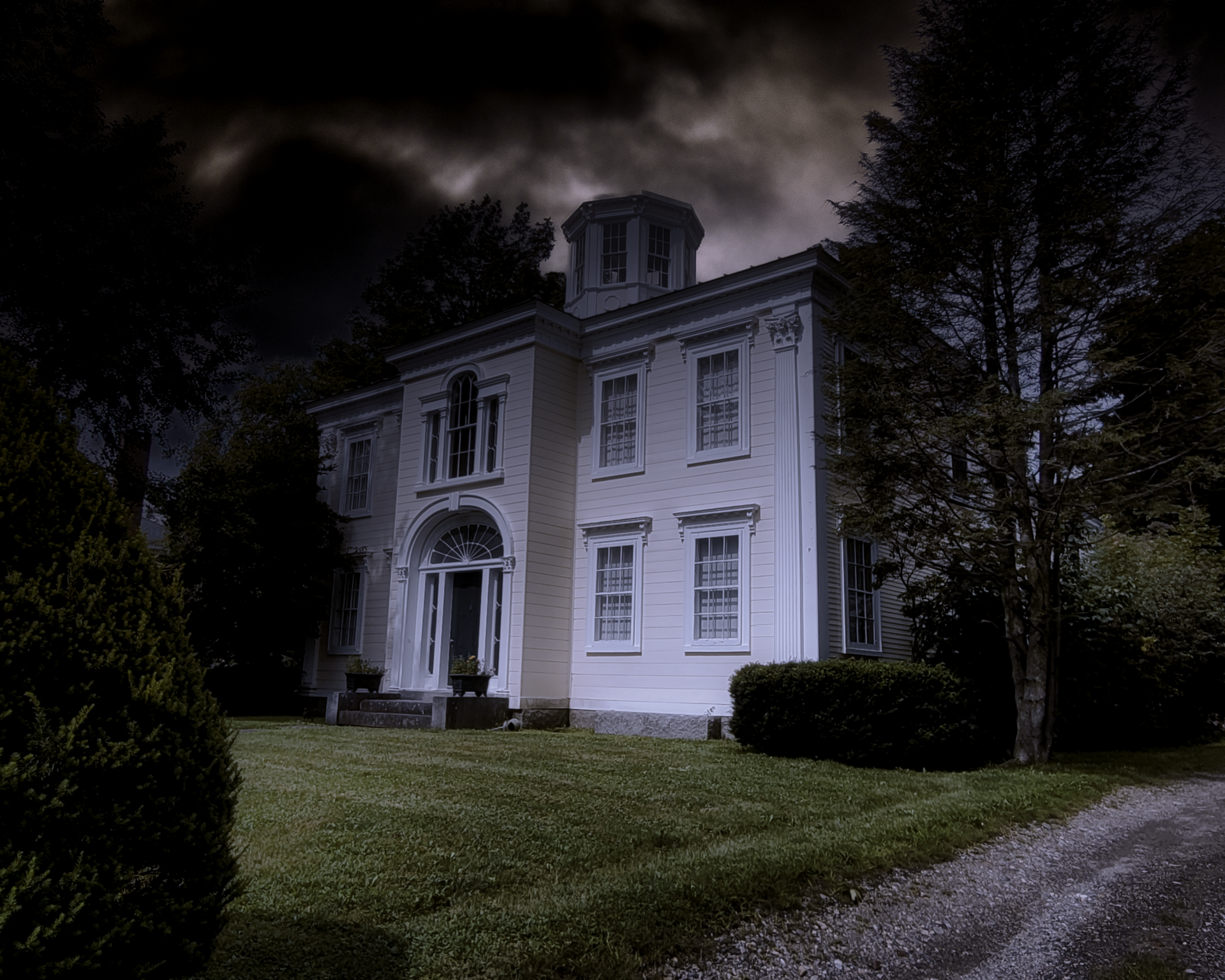 A large white house with a dark sky in the background