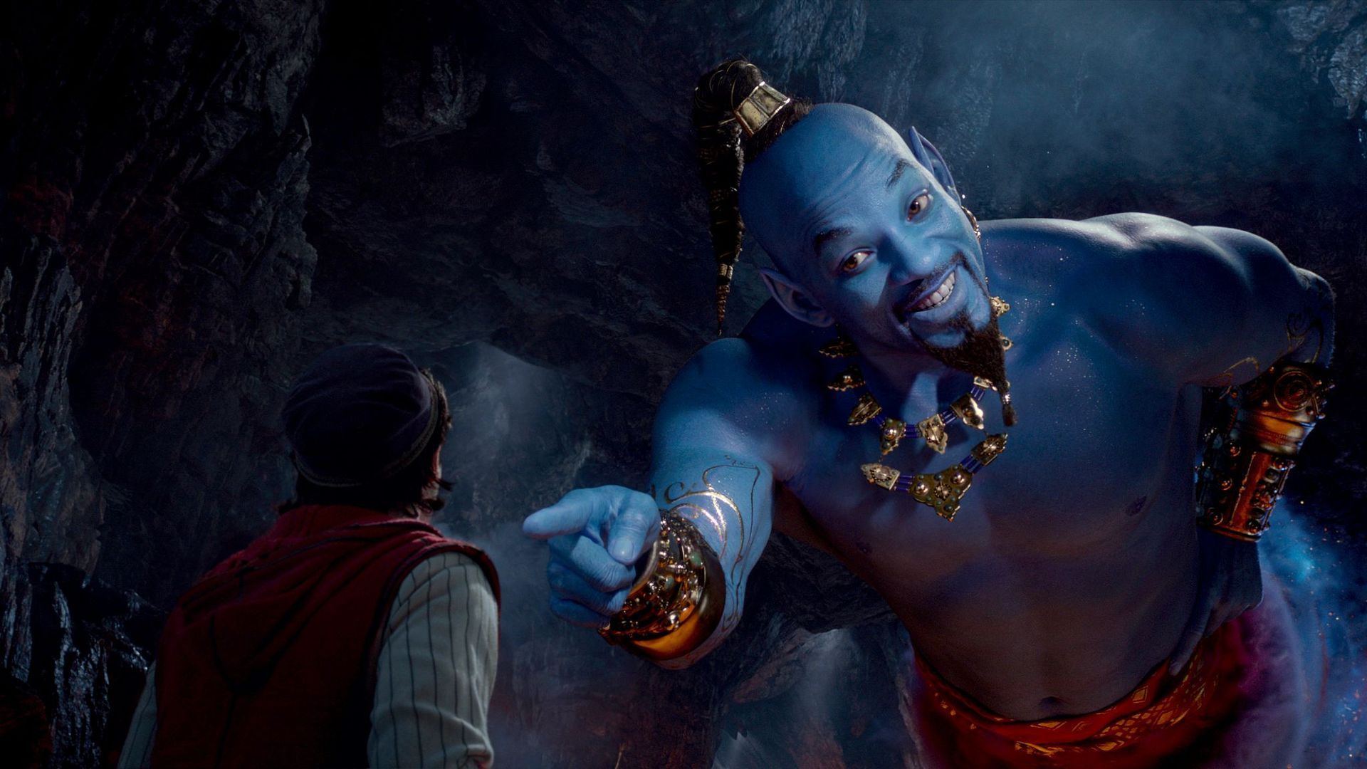 A man is standing next to a genie in a cave.