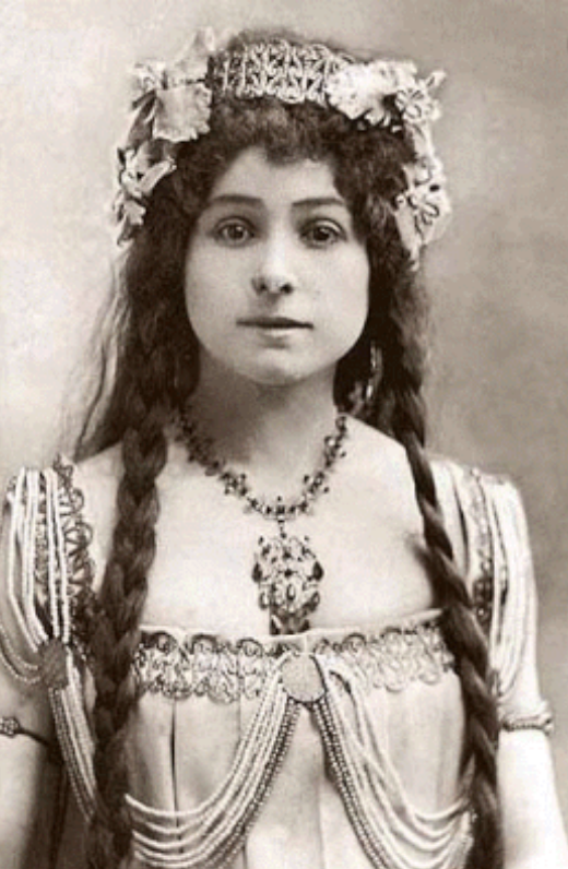 A black and white photo of a woman wearing a tiara and necklace