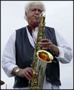 A man in a black vest is playing a saxophone