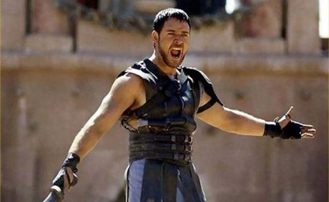 A man in a gladiator costume with his arms outstretched