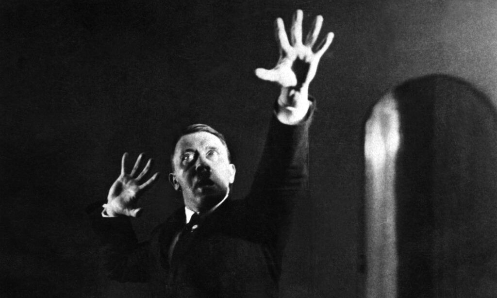 A black and white photo of a man with his hands in the air