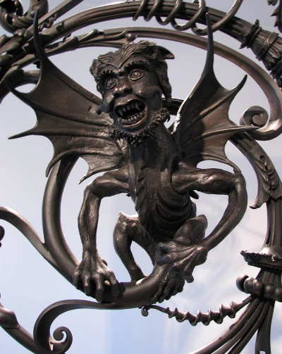 A statue of a gargoyle with wings and a beard