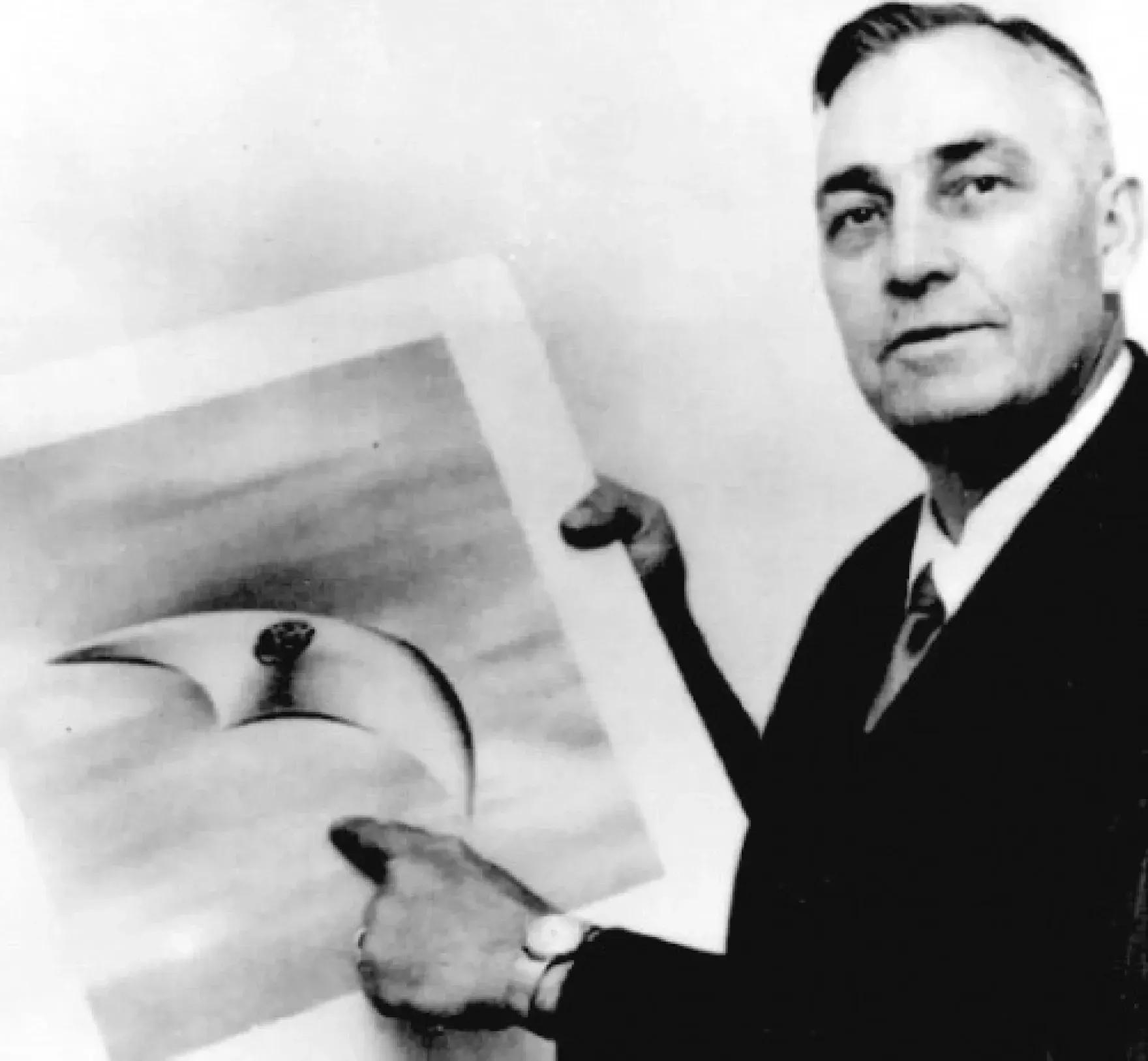 Kenneth Arnold holding an artists rendition of his UFO sighting