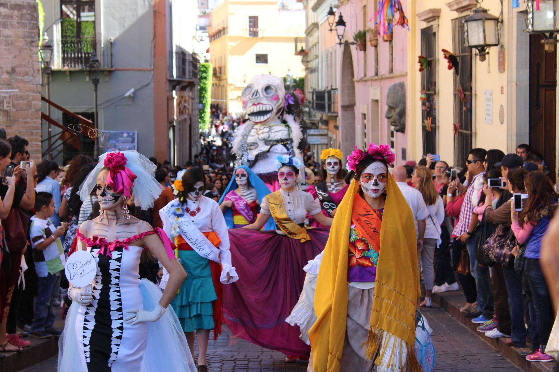 A group of people dressed as skeletons are walking down a street.