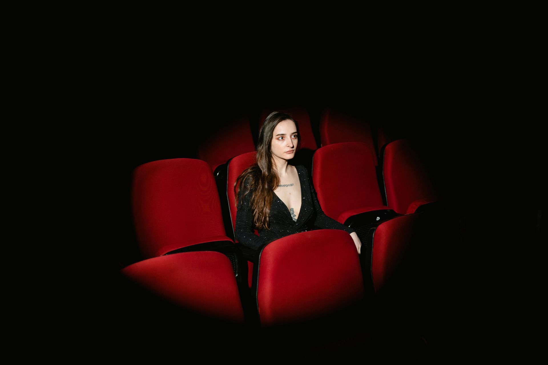 ghostly woman sitting in a theater seat