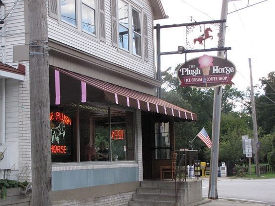 A store front with a sign that says plush horse