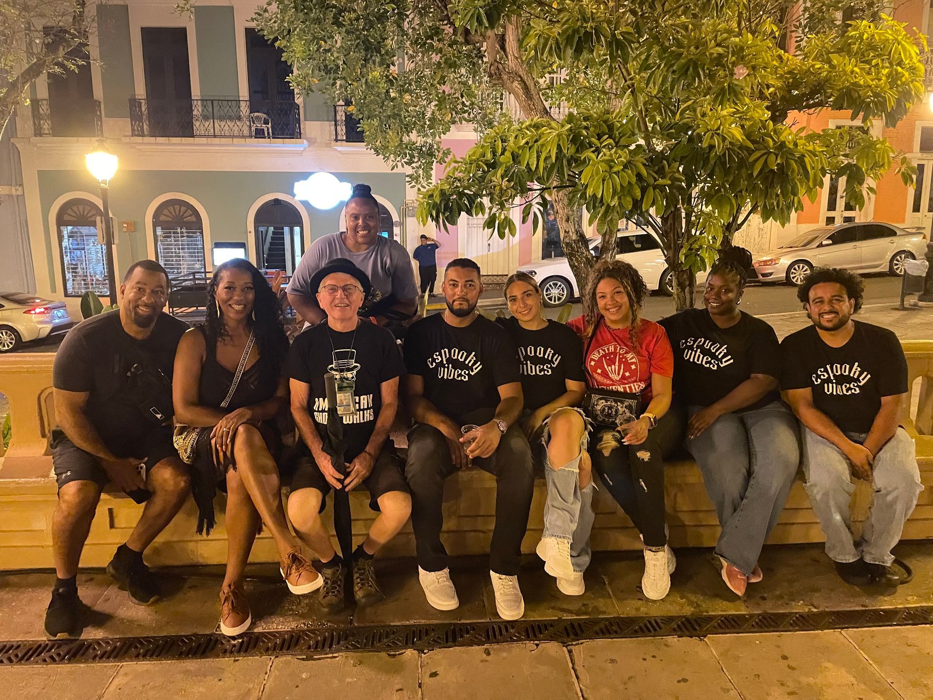 A group of people are posing for a picture while sitting on a bench