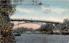 A black and white photo of a bridge over a river.