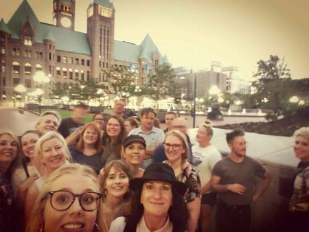 A group of people posing for a picture in front of a clock tower