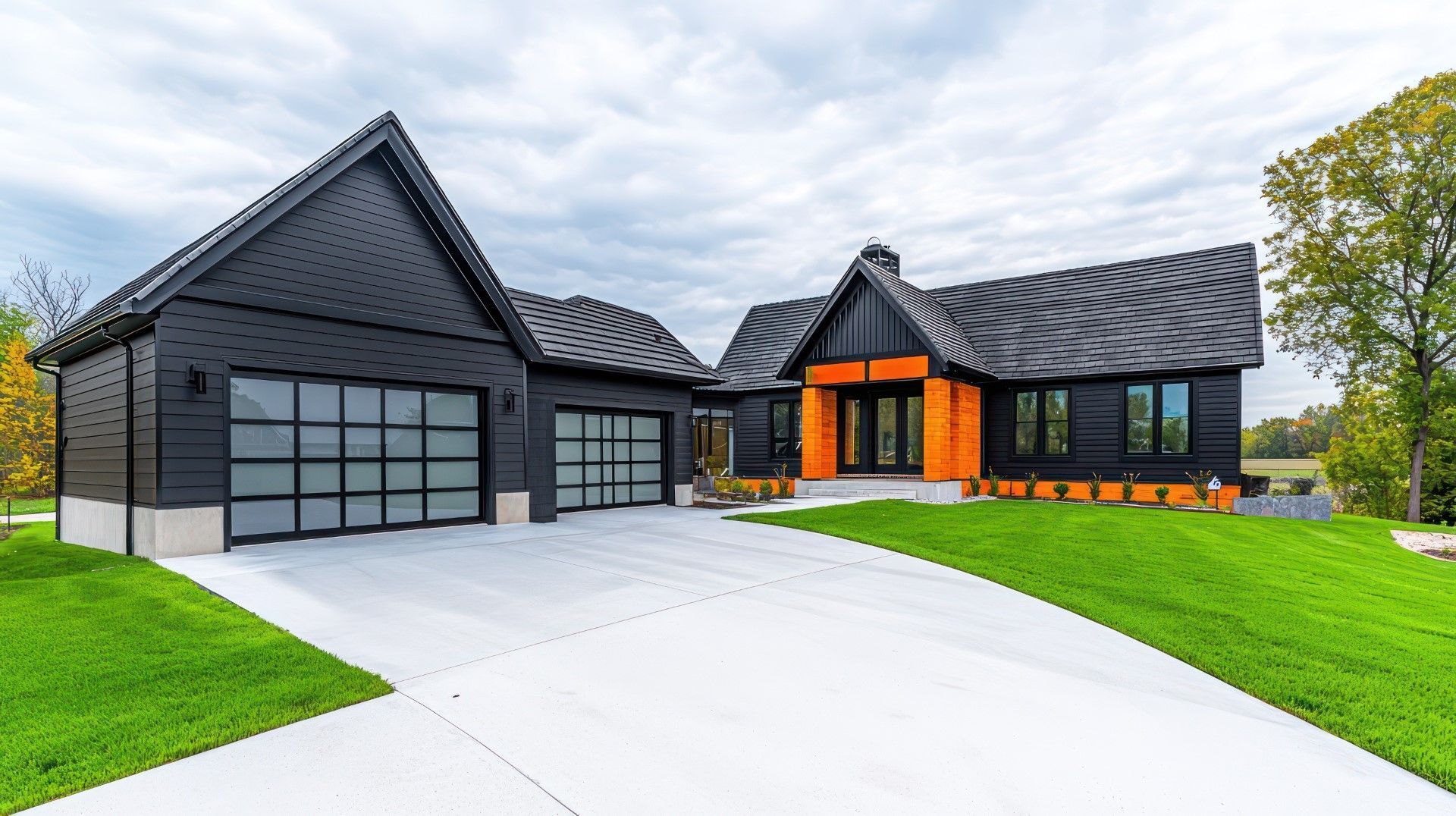 Modern black house with garage, orange accents, and green lawn.