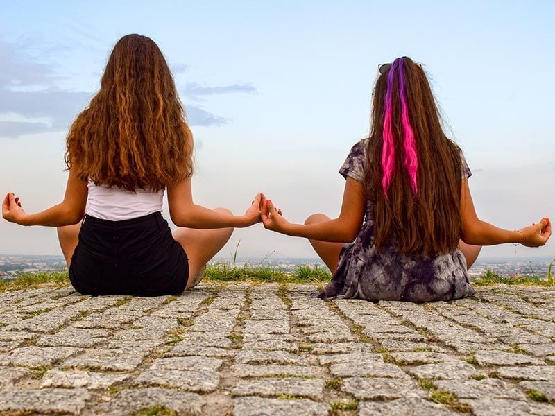 Deux filles assises sur le sol dans la position du Lotus