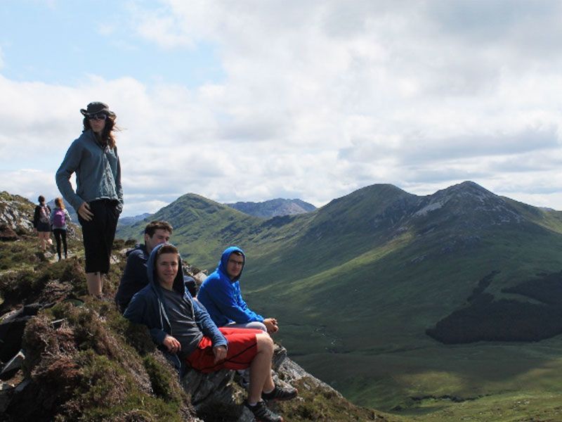 Un groupe de jeunes assis en haut d'une montagne
