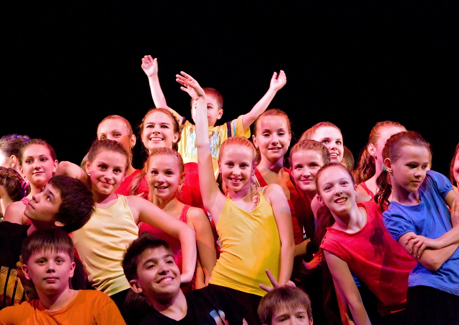 Une troupe d'enfants qui font de la danse sur une scène