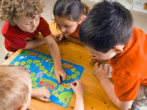 4 enfants jouent à un jeu de société sur une table