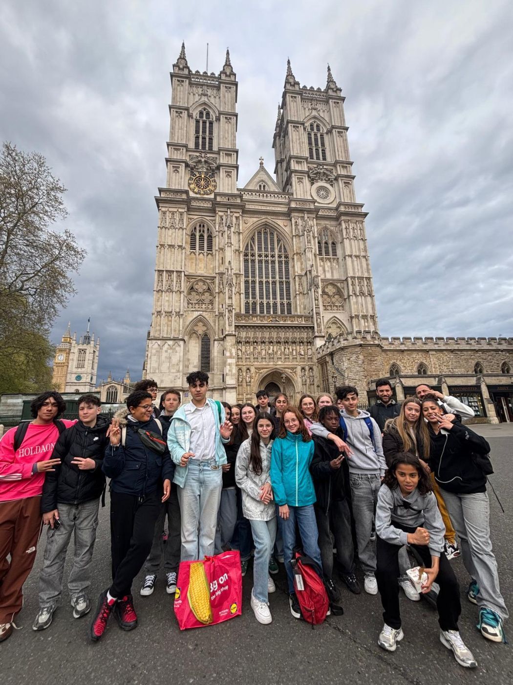 Un groupe de jeunes gens en train de poser devant un monument
