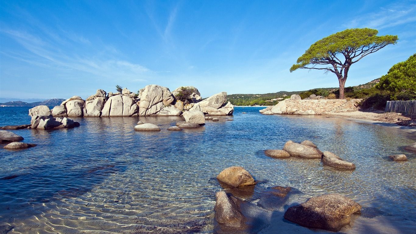 Rocher dans la mer avec de la verdure et un grand ciel leu